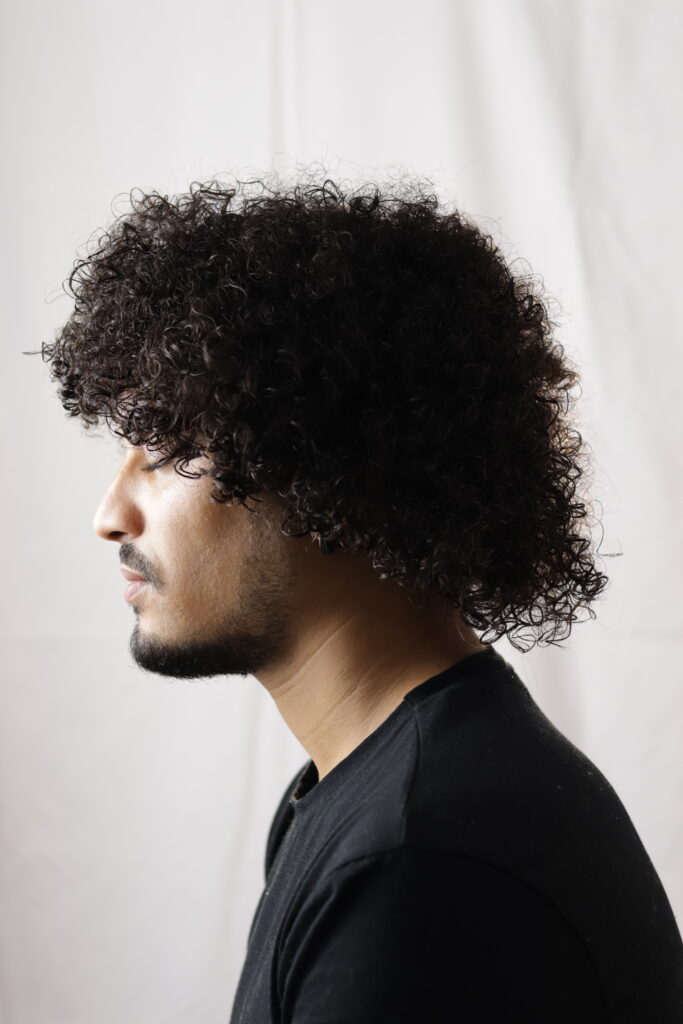 Capelli ricci con lunghezze sulla nuca, vista di profilo